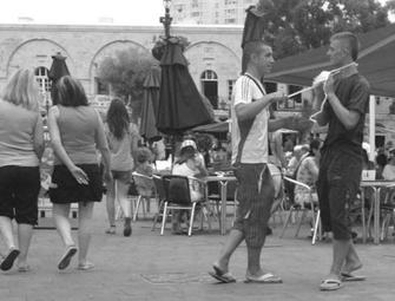 Un joven se quita una mascarilla en la plaza de Casemates.