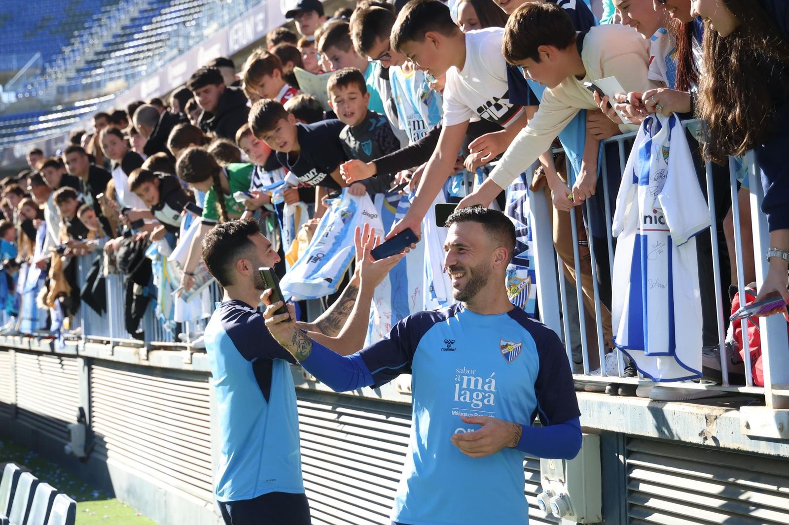 Los jugadores posan para fotografías con los niños