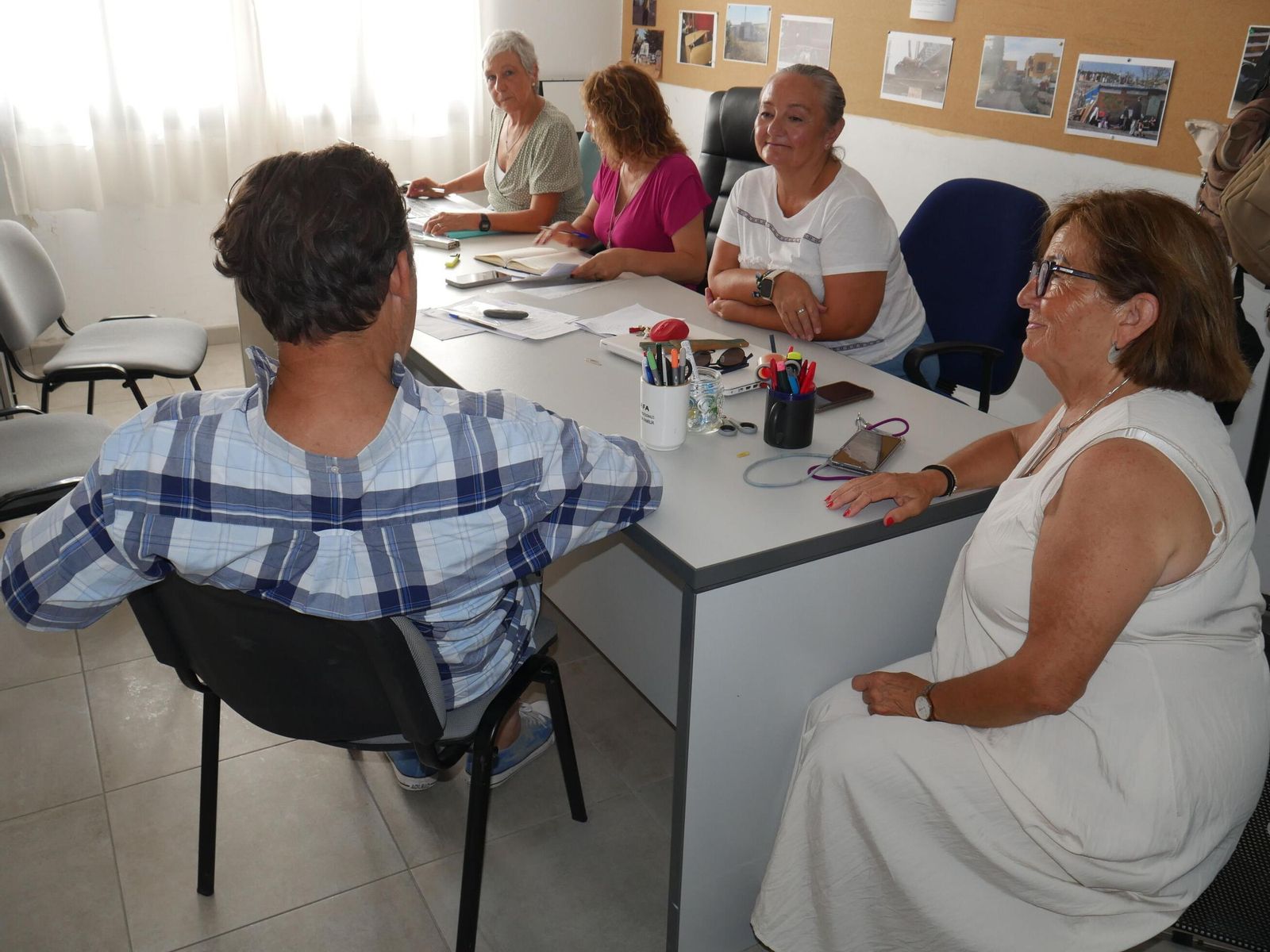 La junta directiva de PESHO-DE atiende a Antonio, una persona sin hogar (de espaldas en la imagen).