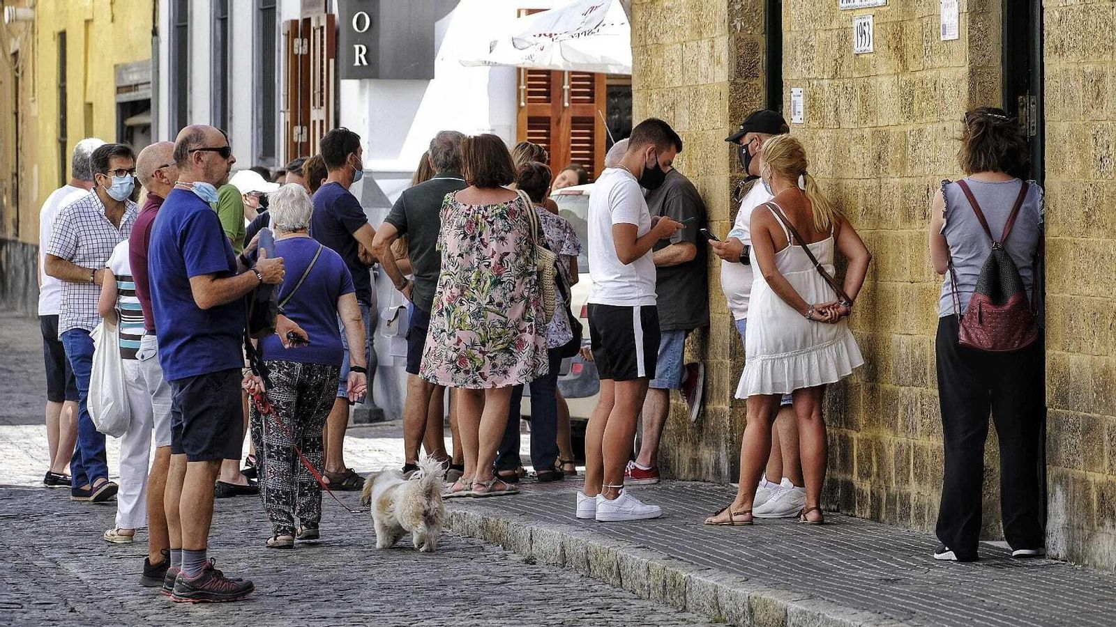 Varias personas esperan en el exterior de la Taberna Casa Manteca.