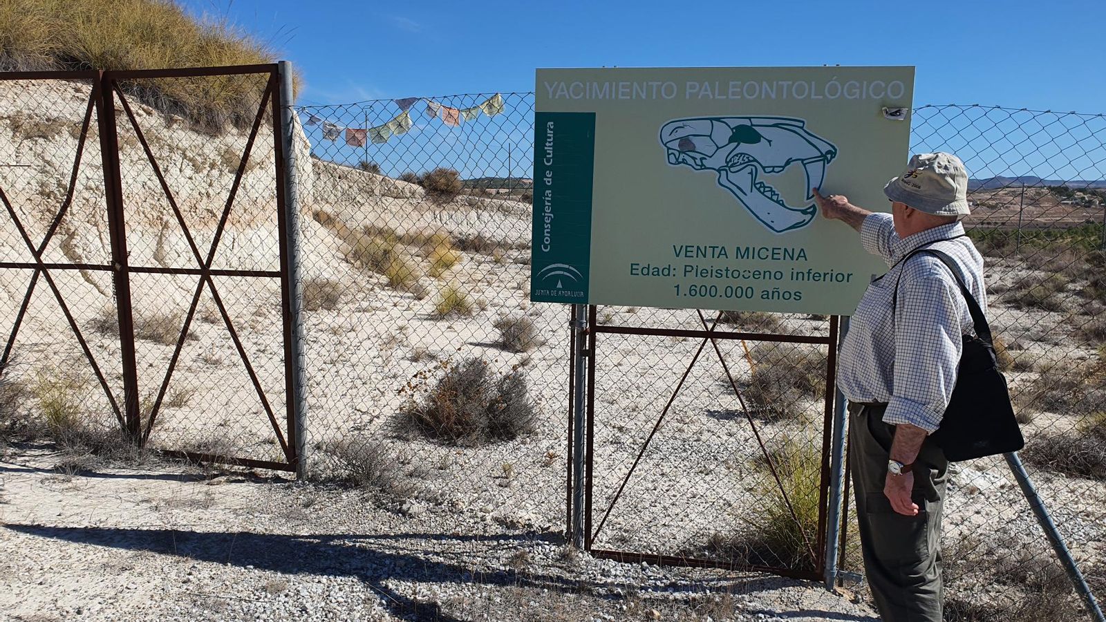Un hombre mira el cartel del Yacimiento de Venta Micena, que se encuentra cerrado.