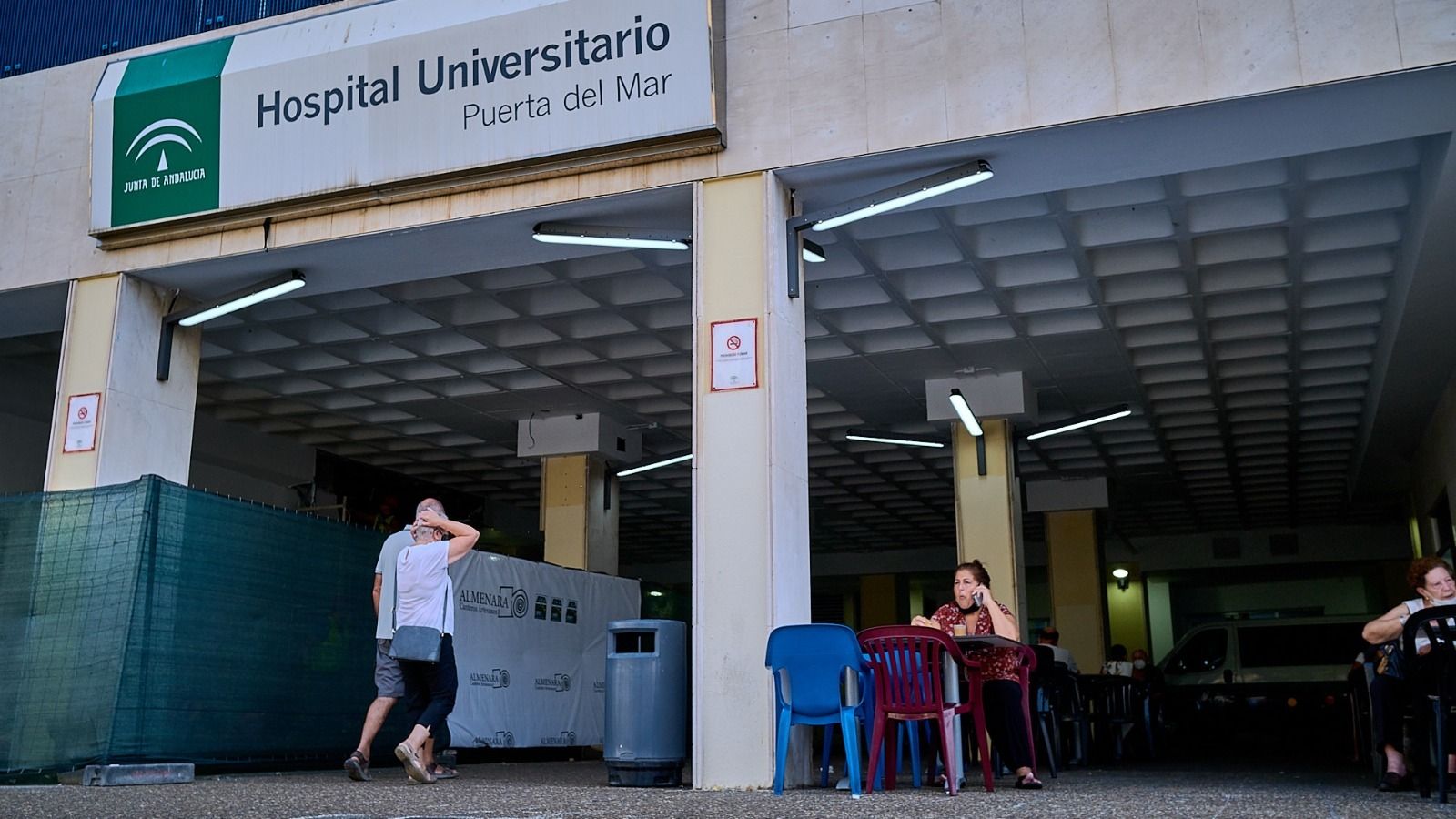 Usuarios en la entrada del hospital habilitada como terraza de la cafetería al inicio de las obras.