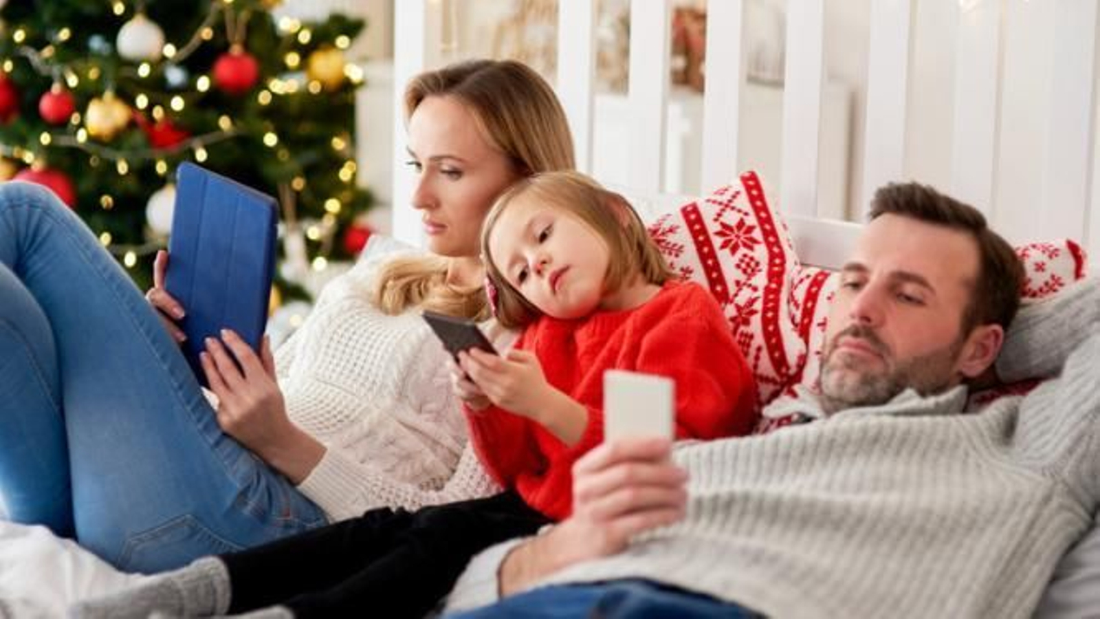 Familia mirando cada uno sus dispositivos en Navidad.