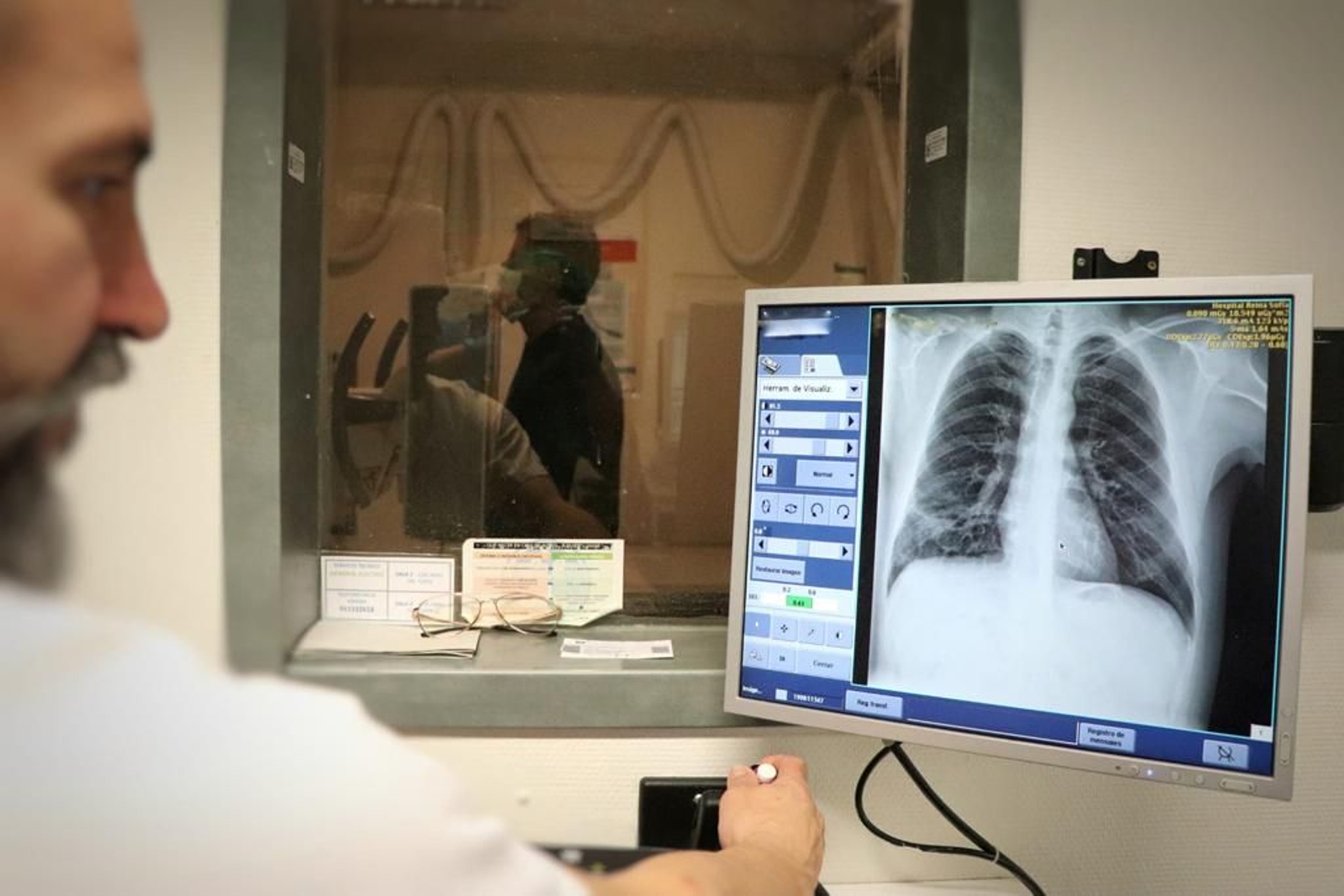 Un médico observa la placa de un paciente.