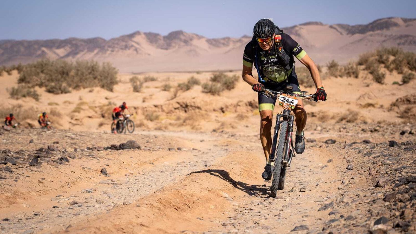 Encima de la bici escalando una subida técnica.