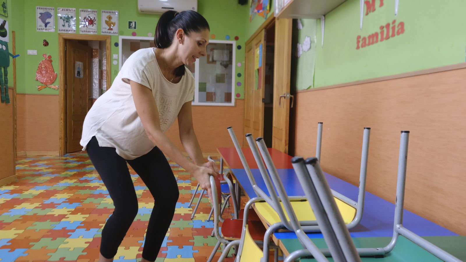 Una de las responsables de la Escuela Infantil El Puzzle 2 ordena las sillas de un aula.