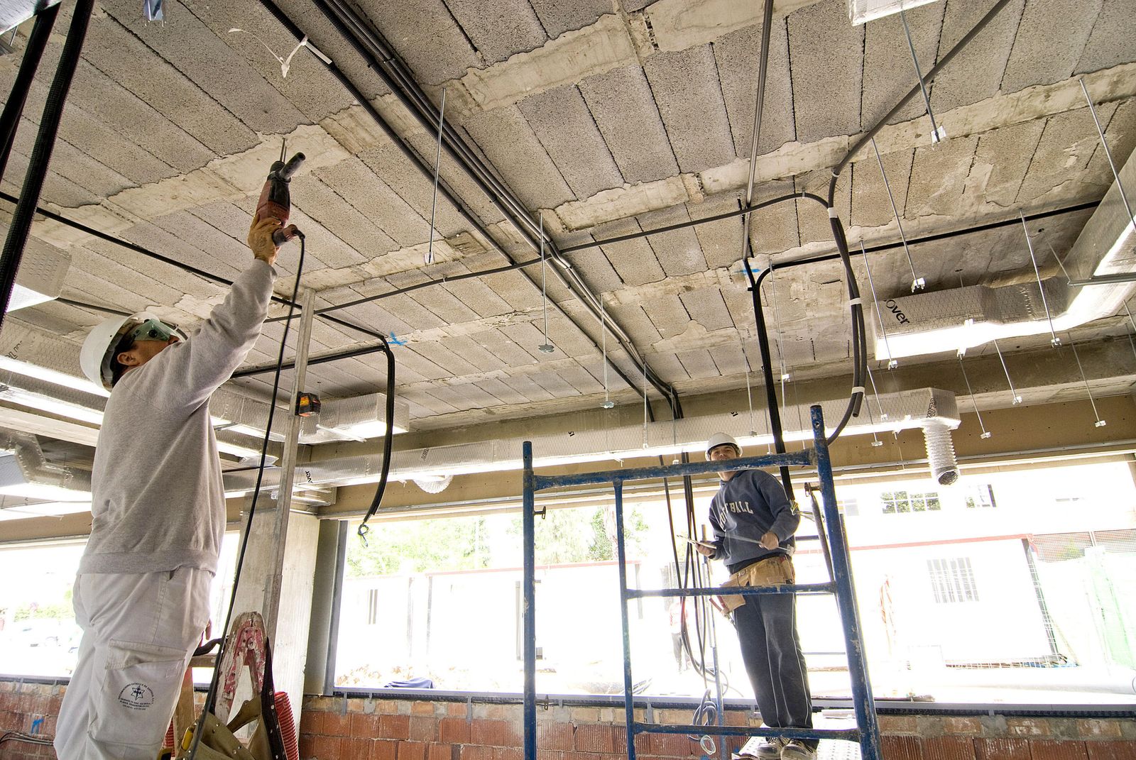 Dos trabajadores realizando sus labores en una obra.