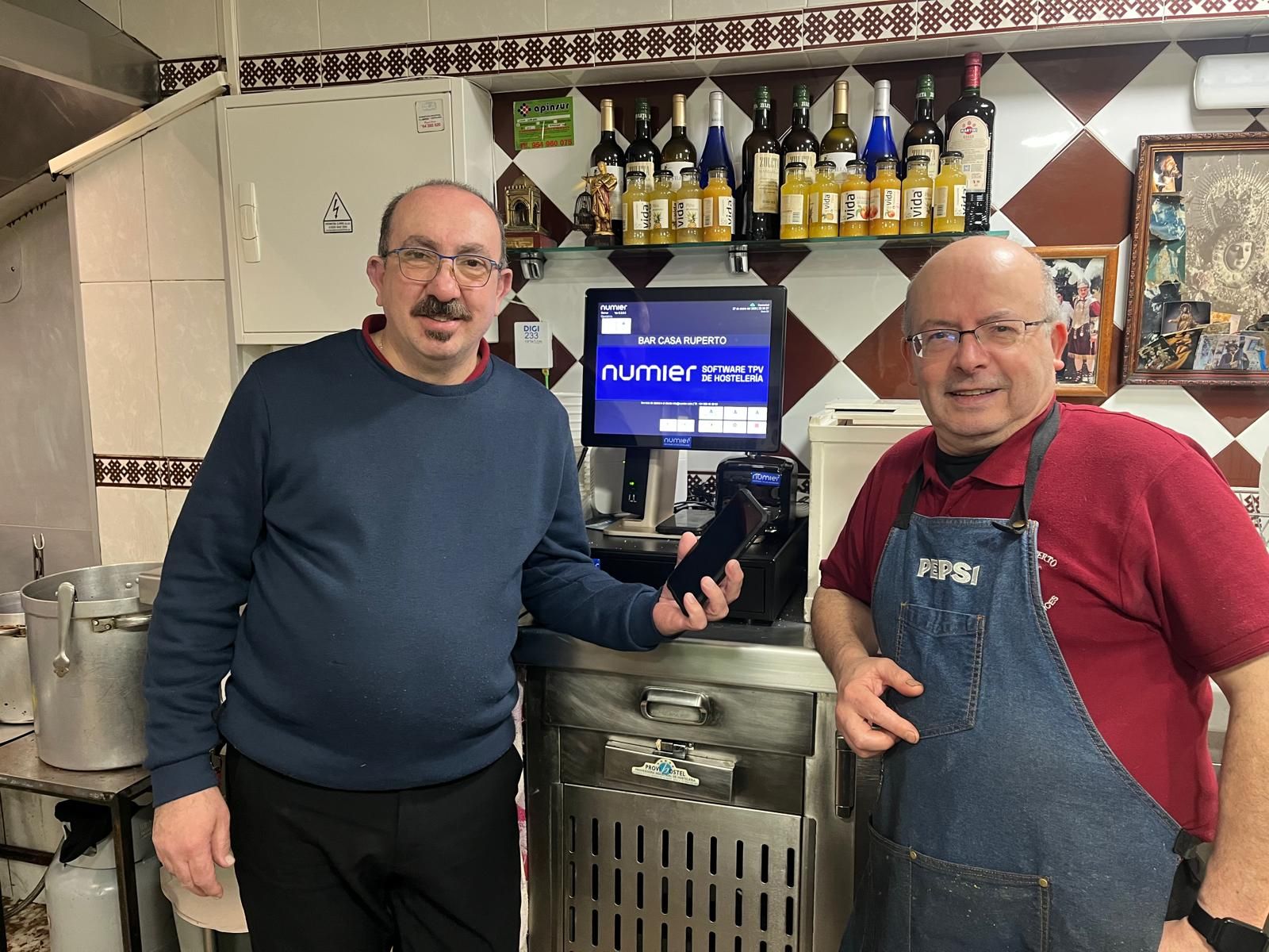 Dos camareros de Ruperto, ante la nueva máquina que sustitiye a las tizas.