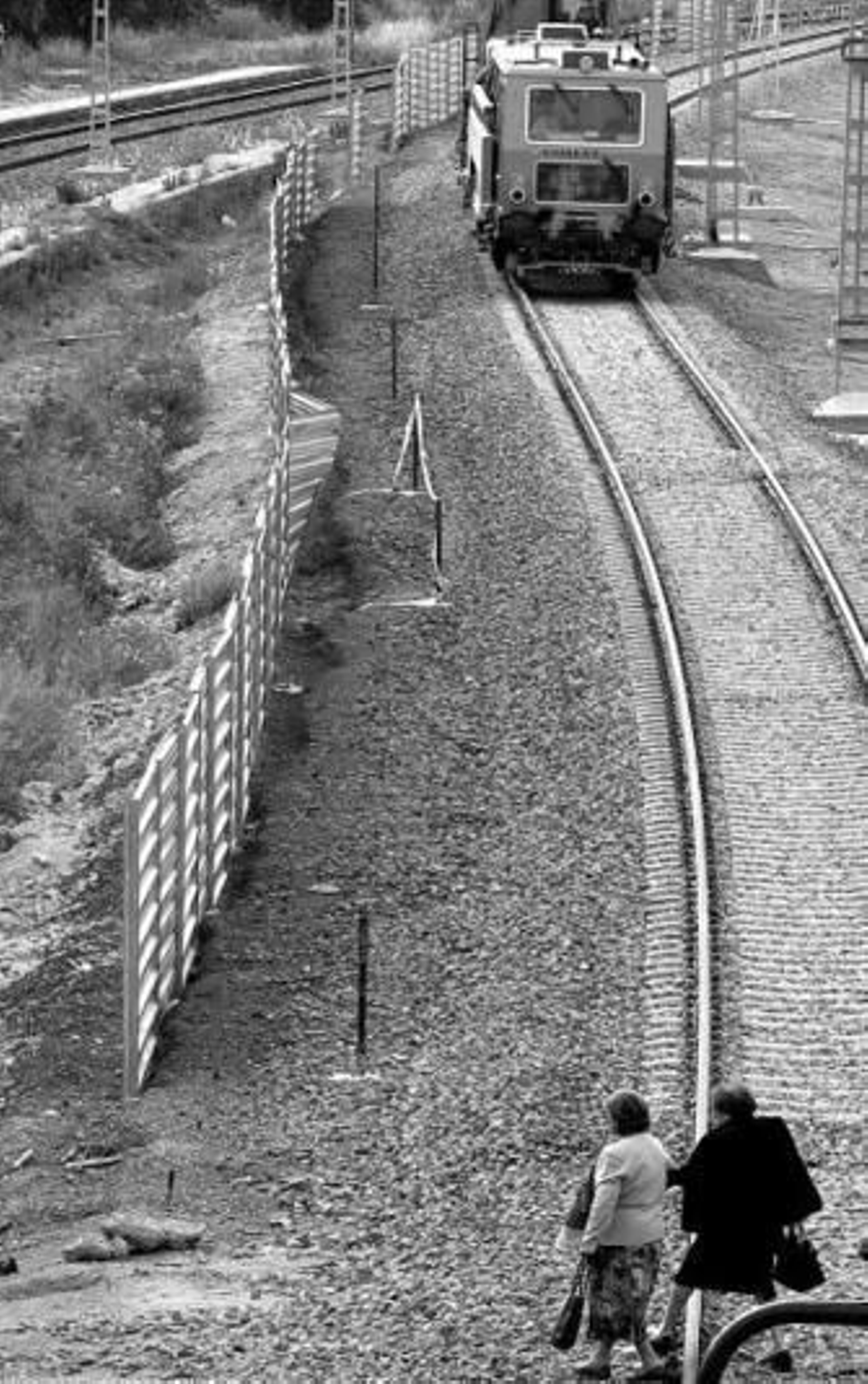 Dos señoras cruzan la vía cerca de la estación de Puerto Real.