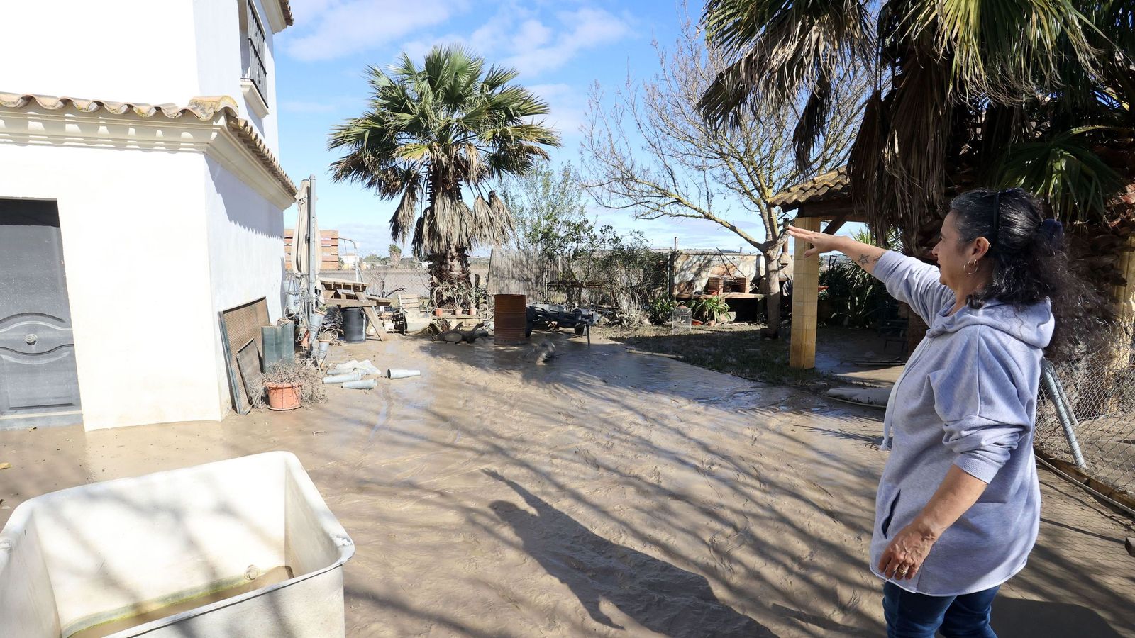 Una vecina muestra los efectos de la riada en su casa.