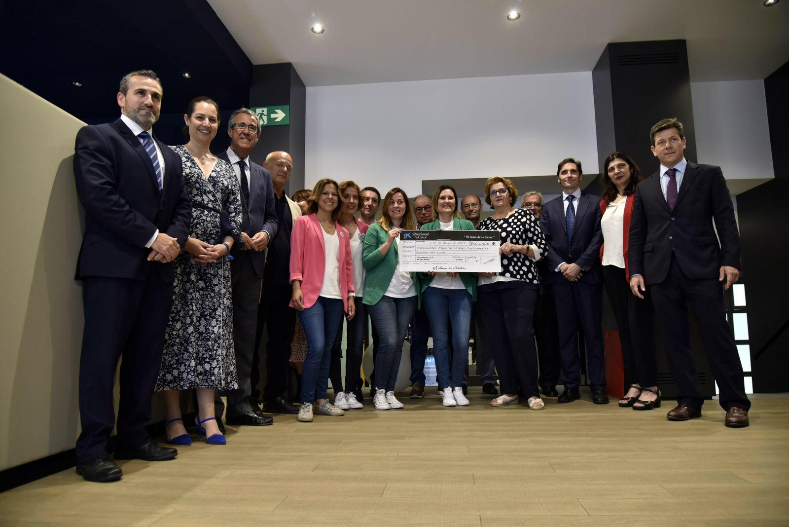 Responsables de Caixabank y de los colectivos posan con el cheque.