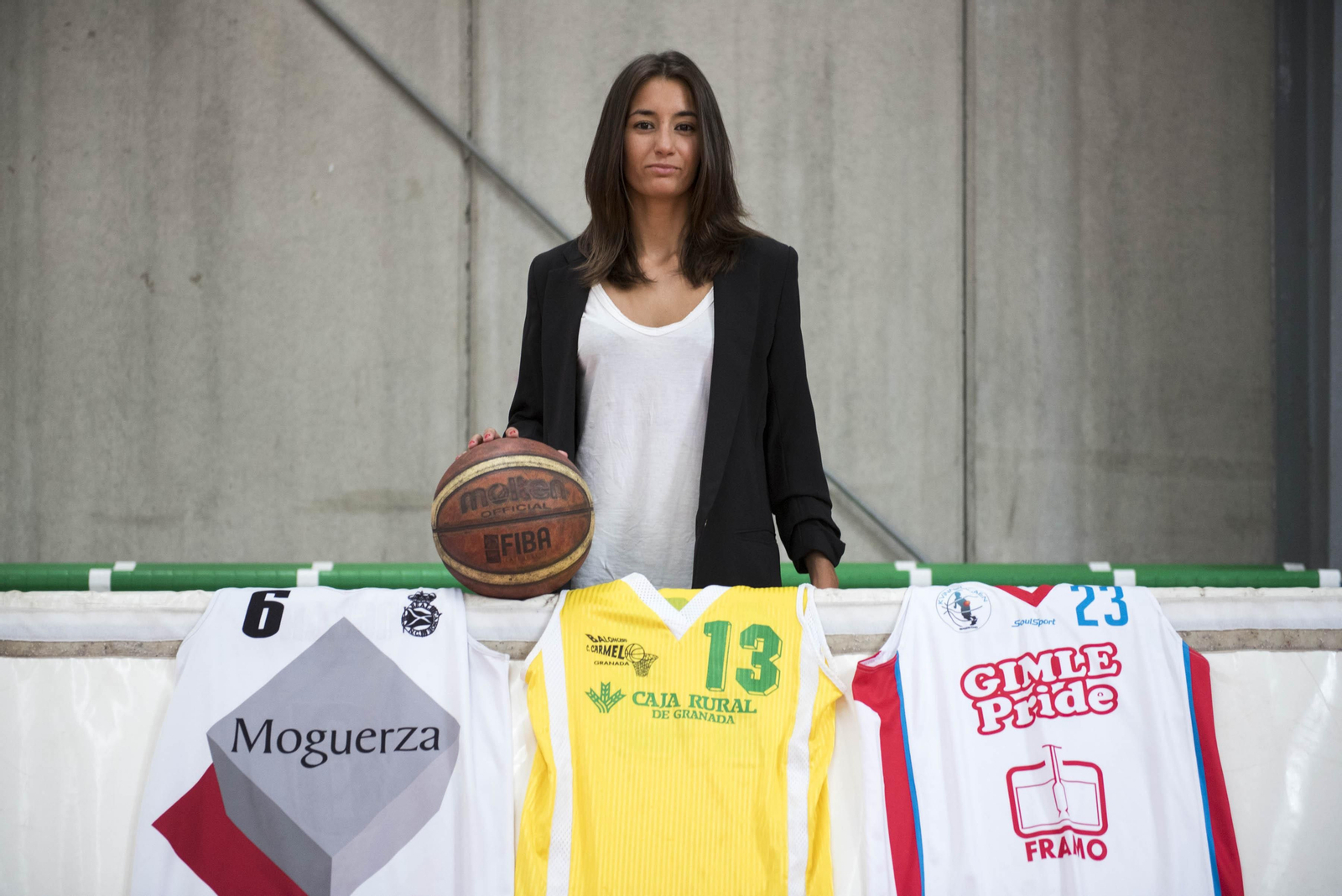 Ángela Escobar posa con las camisetas de los tres equipos más importantes de su carrera: Real Canoe, El Carmelo y Gimle Basket.