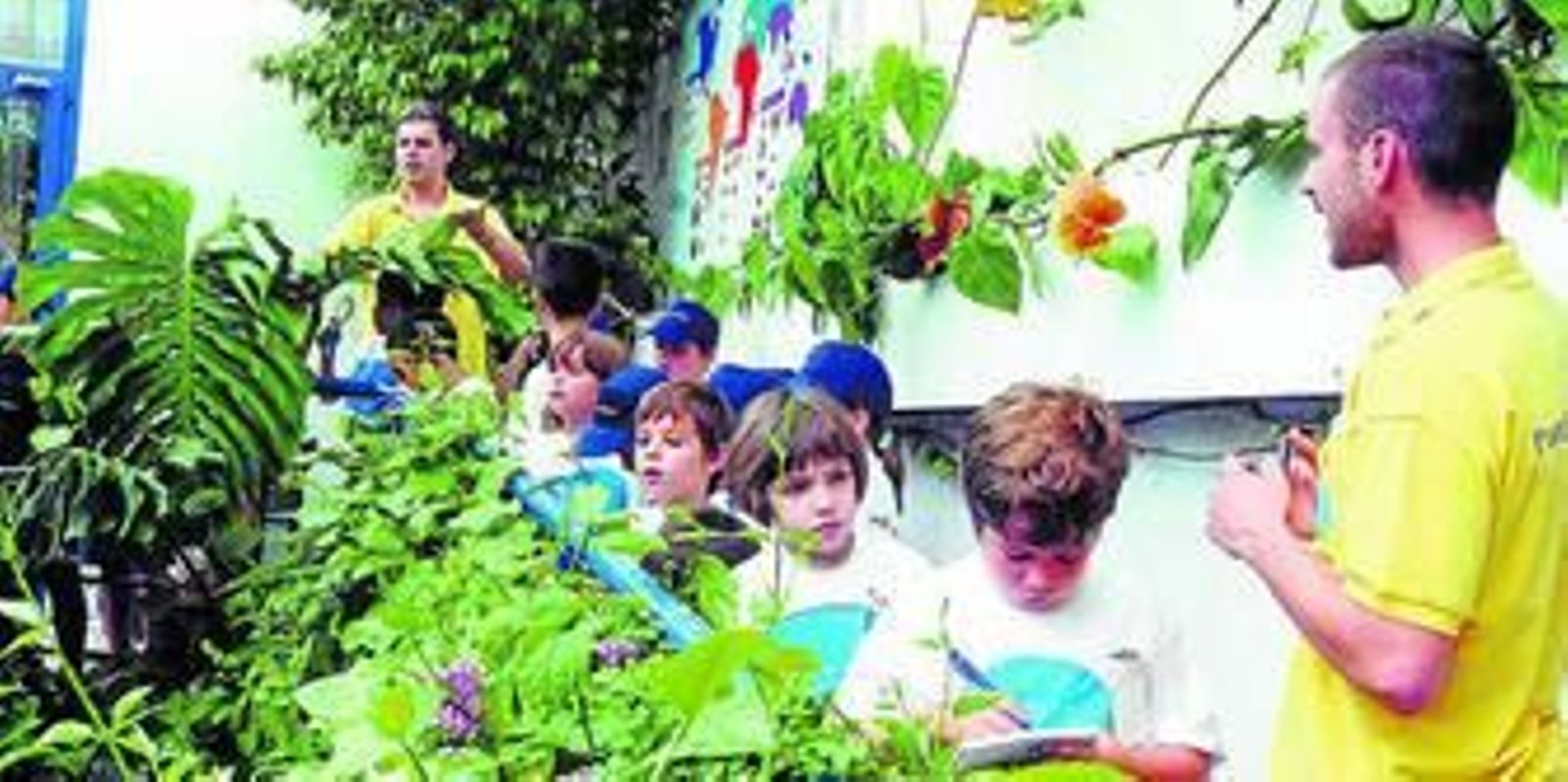 1. Los pequeños volverán a descubrir los secretos del Bosque de los Sentidos  2. Una niña mira con una lupa una mariposa de cerca en la anterior edición de Verano con ciencia. 3. Los pequeños escuchan con atención a uno de los monitores que les acompañan por todo el viaje.