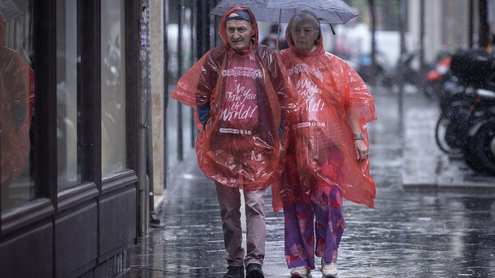 Dos personas se protegen de la lluvia en el centro de Sevilla.
