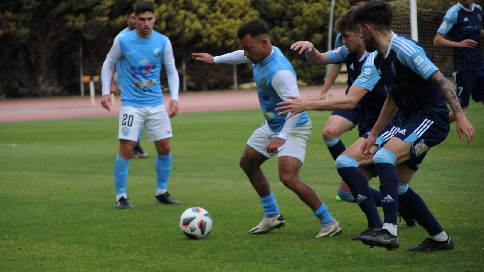 Juancho protege el esférico ante la oposición de varios rivales.