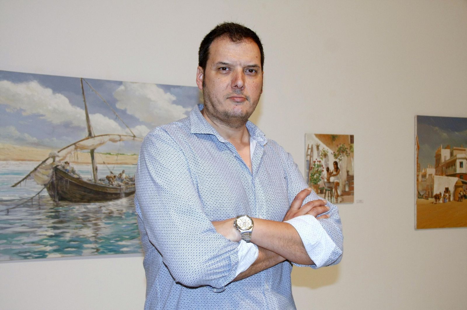 Adrián Ferreras, junto a los cuadros expuestos en el centro cultural Alfonso X El Sabio.