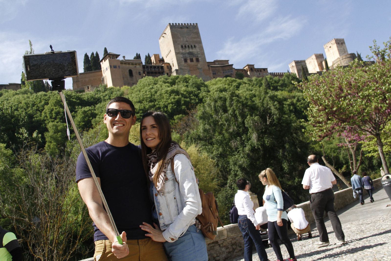 Dos turistas se hacen un 'selfie' con la Alhambra de fondo.