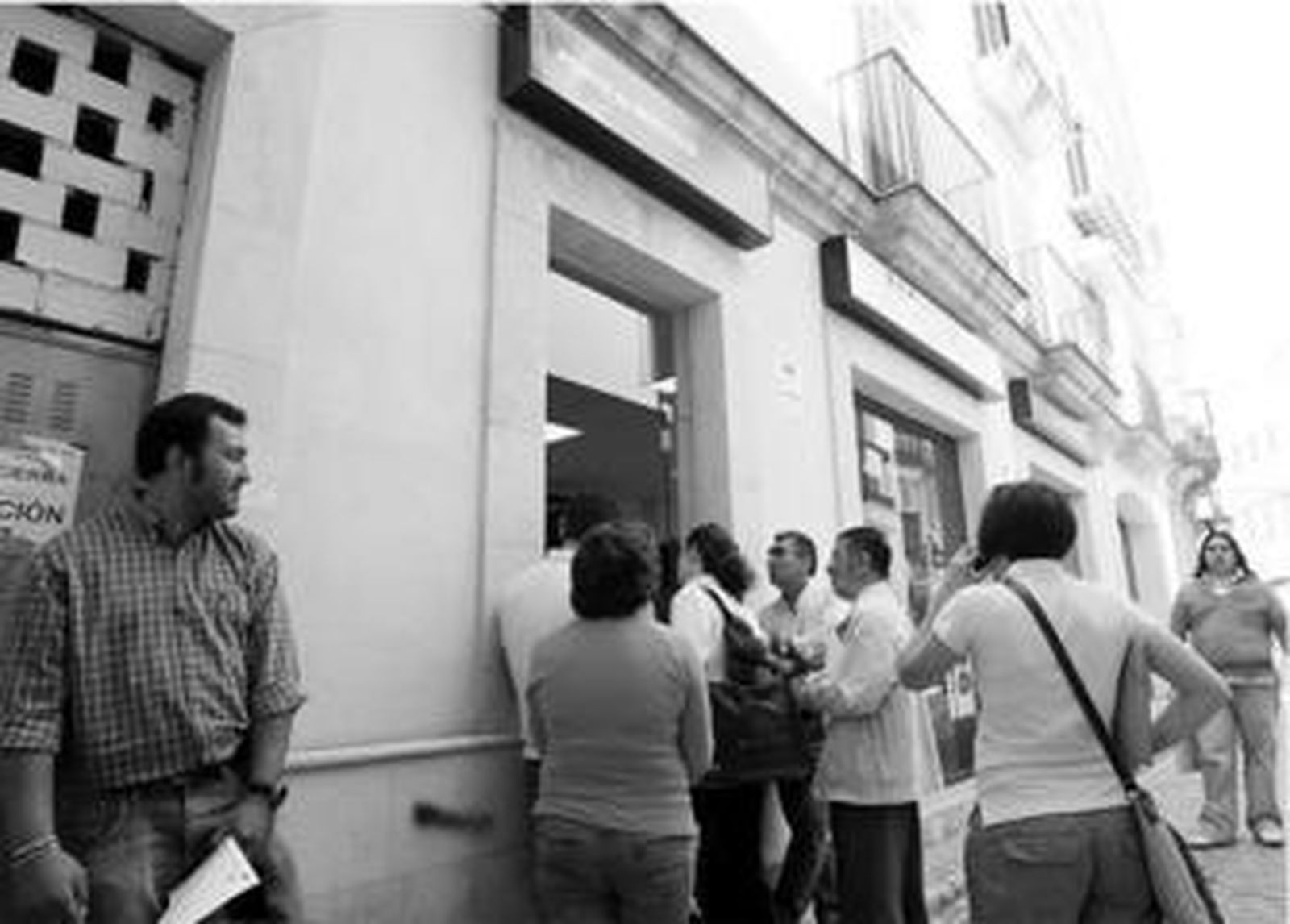 Caseteros y feriantes hacen cola ayer a mediodía ante la sucursal de Endesa en la calle San Cristóbal.