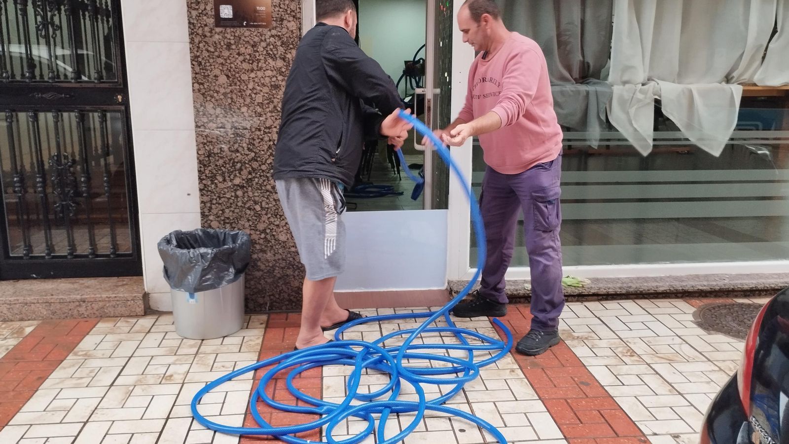 Dos hombres achican agua en la Iglesia Evangélica Ucraniana, en la calle Jerónimo Bobadilla. Dos hombres achican agua en la Iglesia Evangélica Ucraniana, en la calle Jerónimo Bobadilla.
