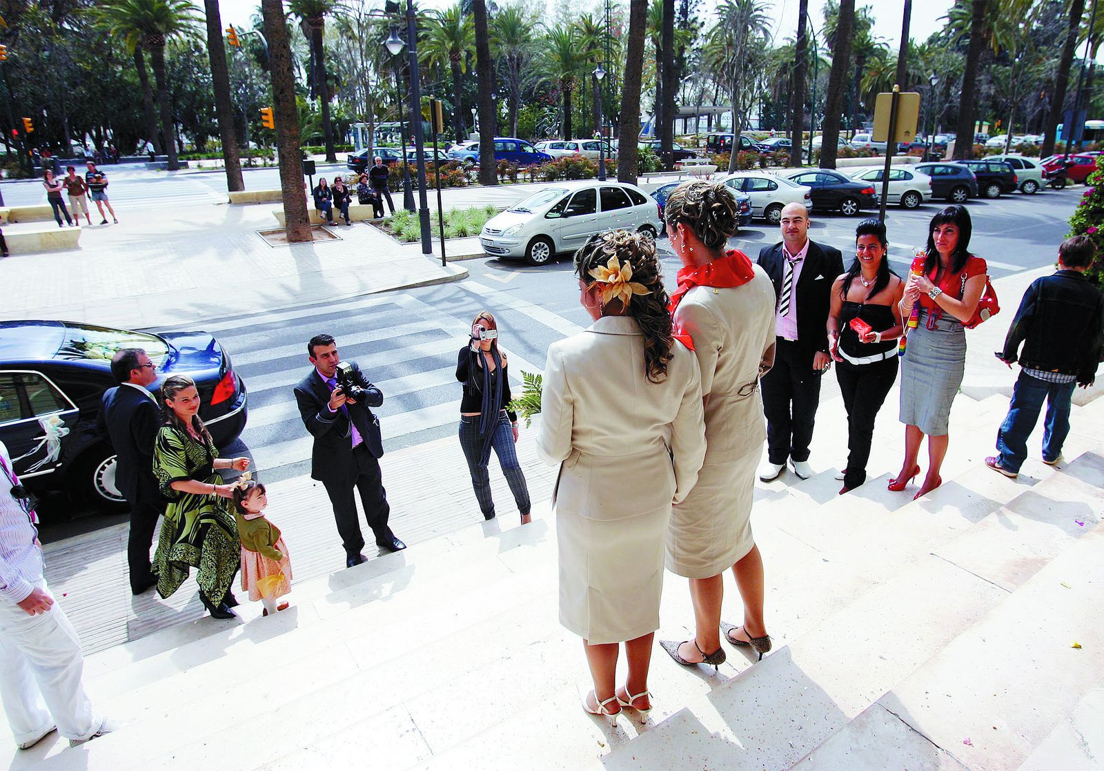 Una pareja se fotografía tras su boda en las escalinatas del Ayuntamiento de Málaga.