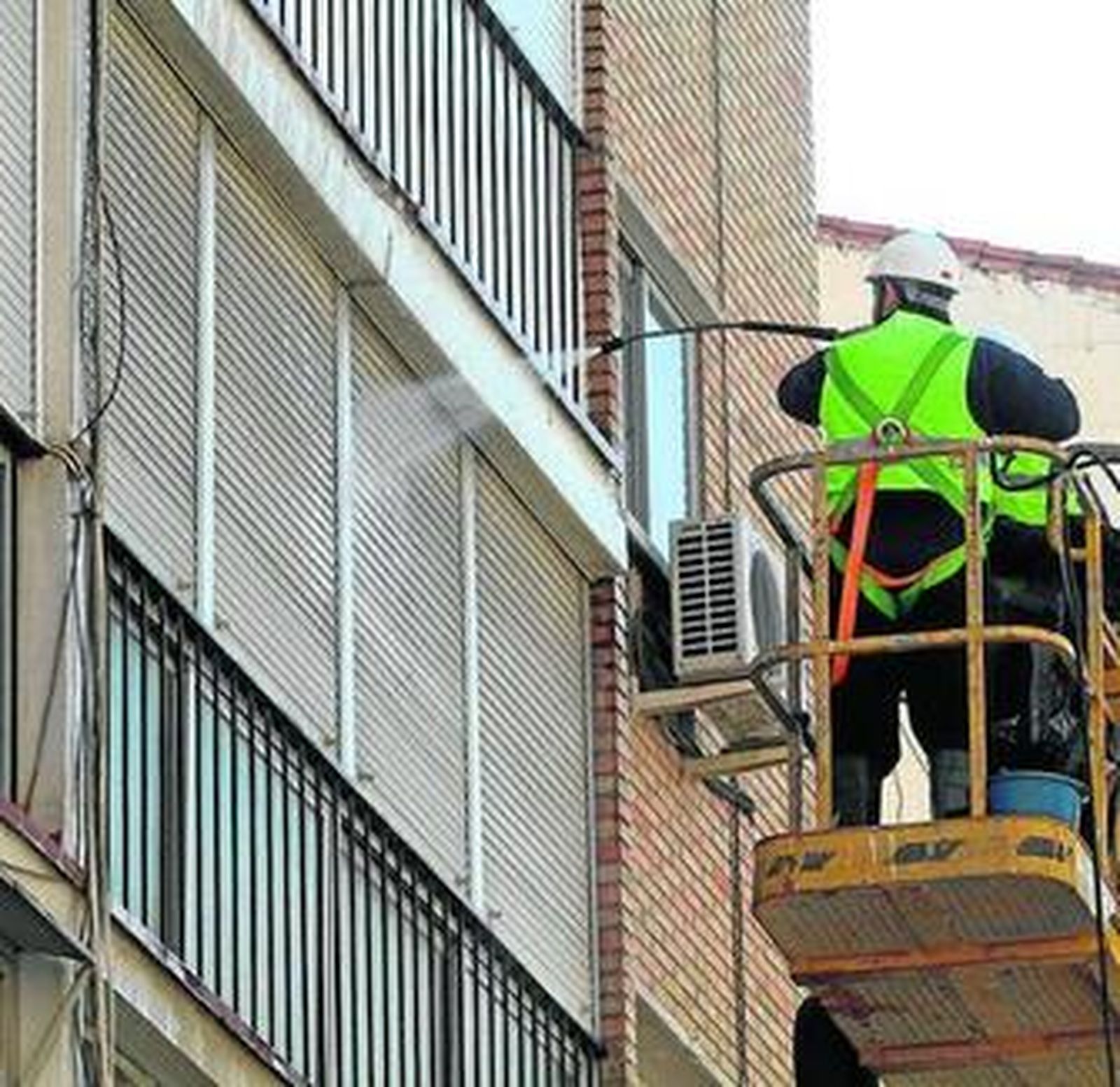 Uno de los operarios del Metro limpia una persiana.