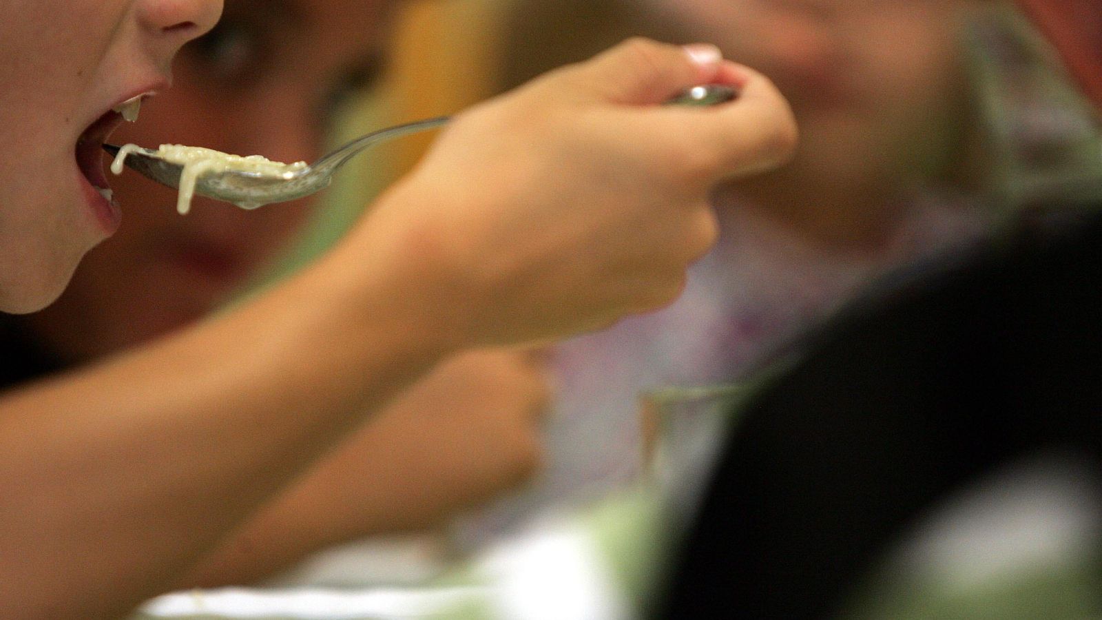 Un alumno almuerza en el comedor de un colegio.