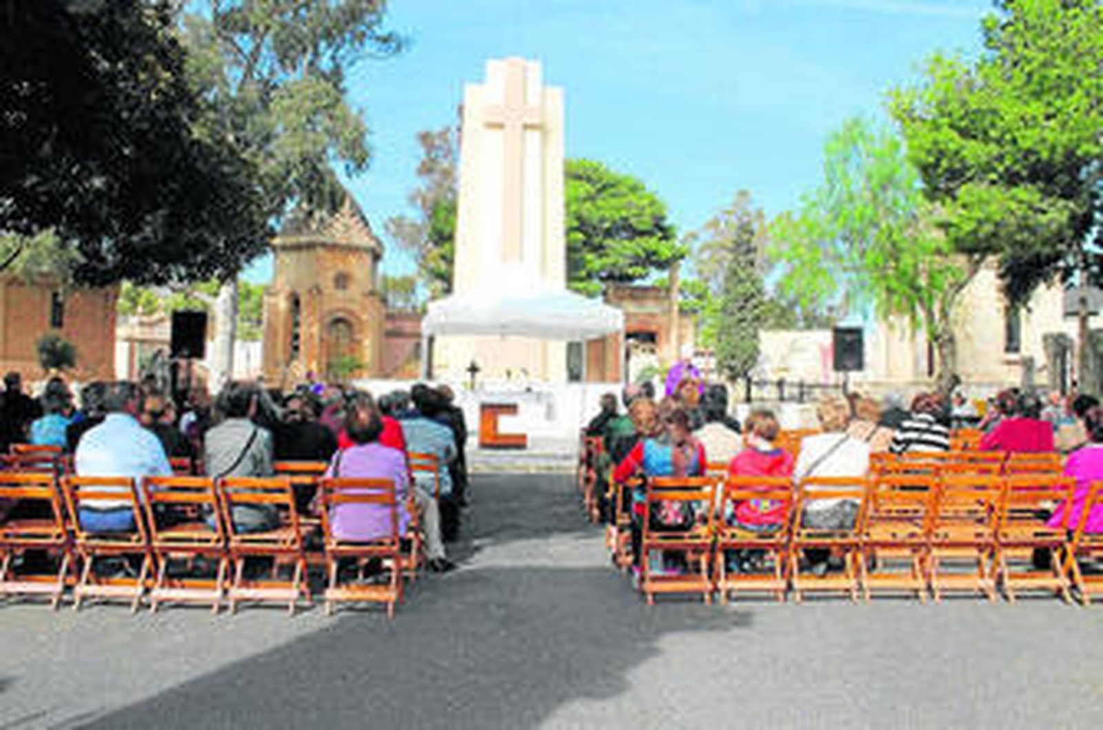 1. Los fieles se reúnen en la plaza de Santa Gema del cementerio de San José para escuchar la palabra del obispo de Almería en el Día de los Difuntos. 2. Puerta de entrada del camposanto más grande de la capital, donde ayer aún había trasiego en los puestos de venta de flores. 3. Monseñor Adolfo González Montes durante la eucaristía. 4. El Ayuntamiento dispuso sillas y una carpa para que se pudiera celebrar la misa. 5. El obispo es el quinto año consecutivo que ofrece una misa en el cementerio de San José.