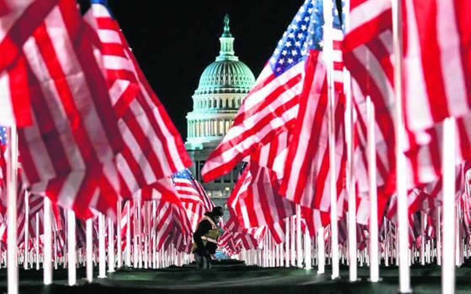 Una persona pasa ayer entre las 200.000 banderas instaladas frente al Capitolio para la investidura hoy del demócrata Joe Biden.