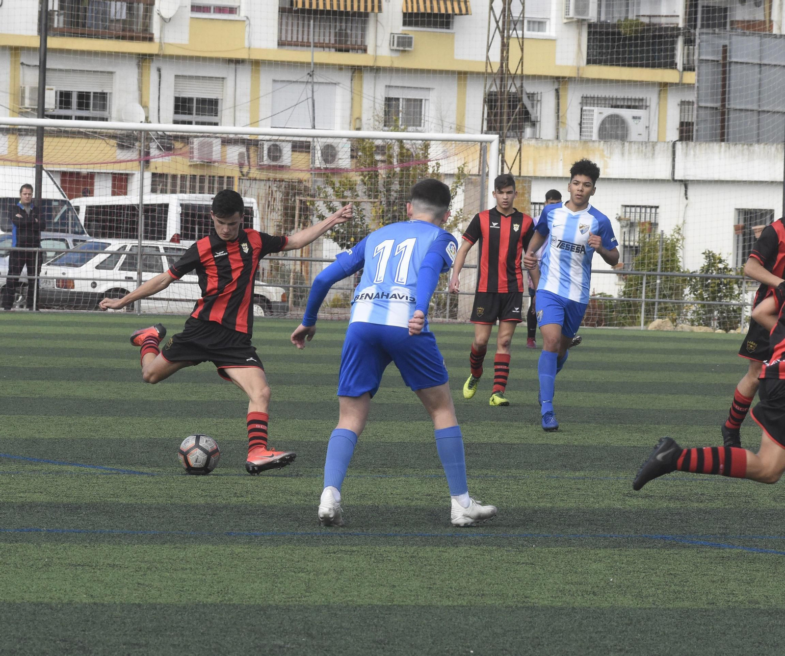 Un jugador del Séneca intenta desplazar el balón ante la mirada de un malacitano.