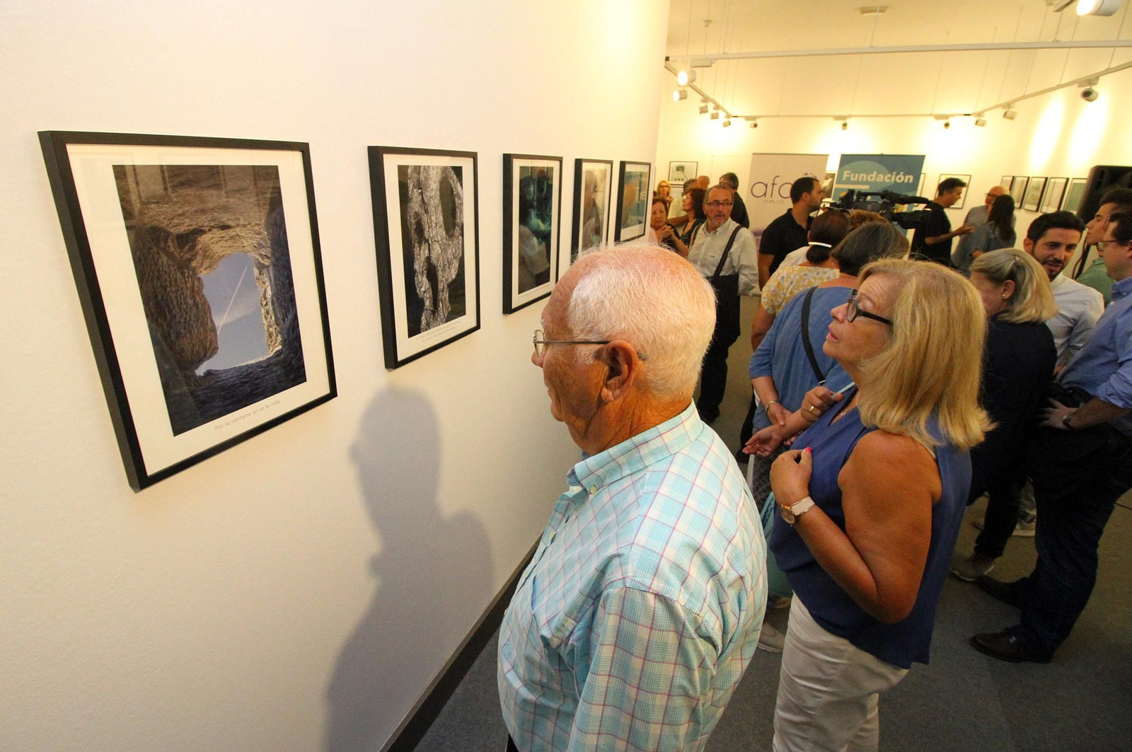 Visitantes de la muestra observan el trabajo fotográfico.