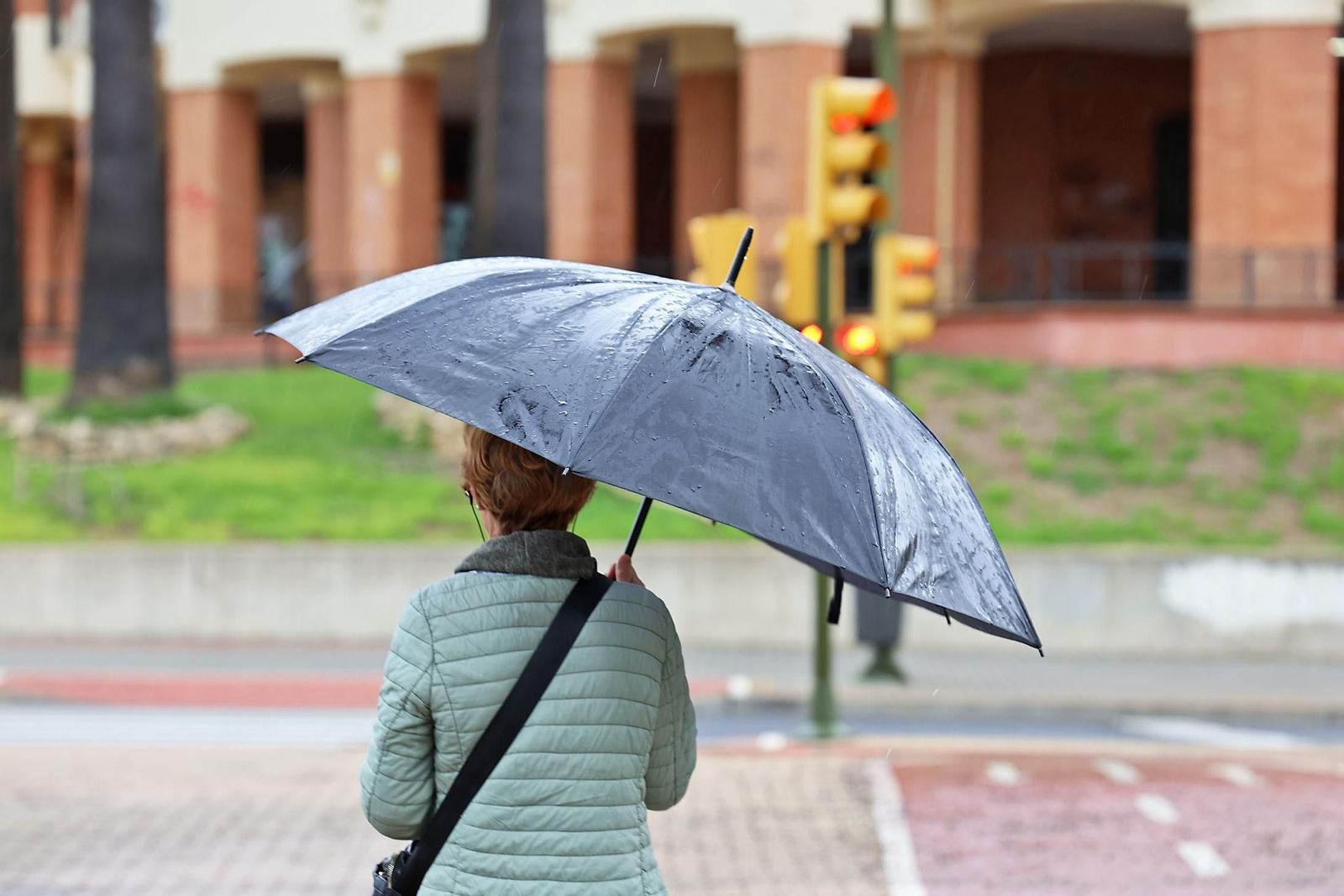 Una mujer se cubre de la lluvia