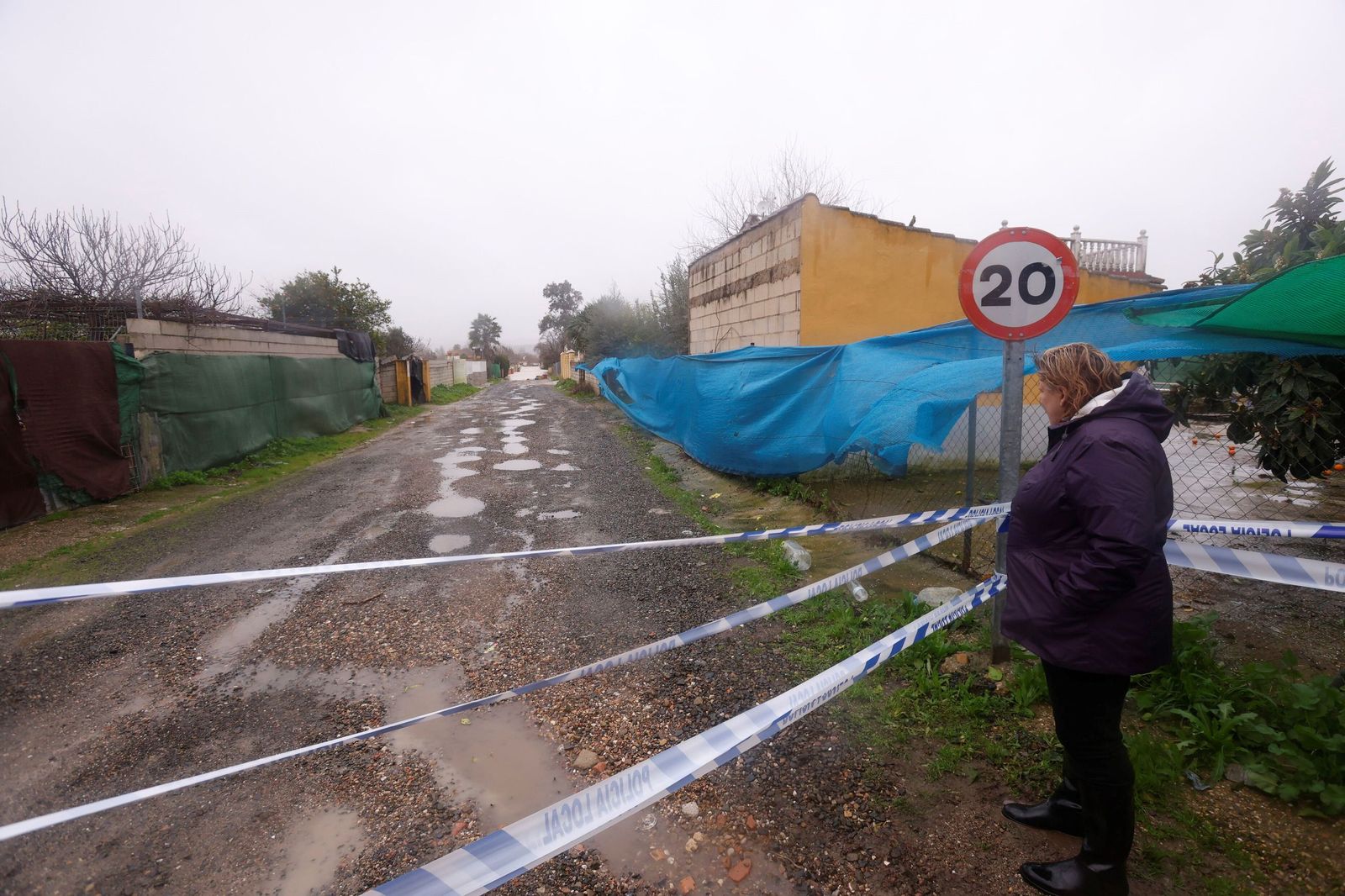 Una mujer, junto a un cordón policial en las parcelaciones de Guadalvalle.