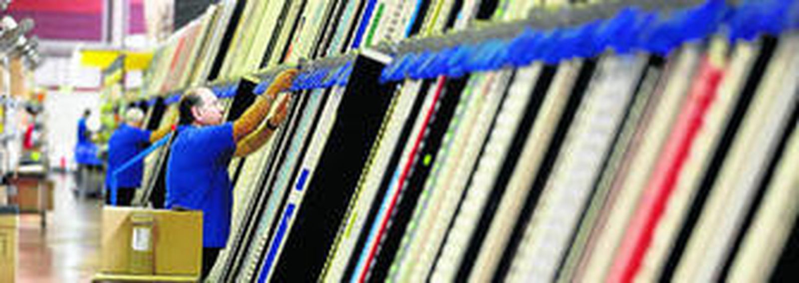 Trabajadores cargan un robot que busca los fármacos solicitados por las farmacias.