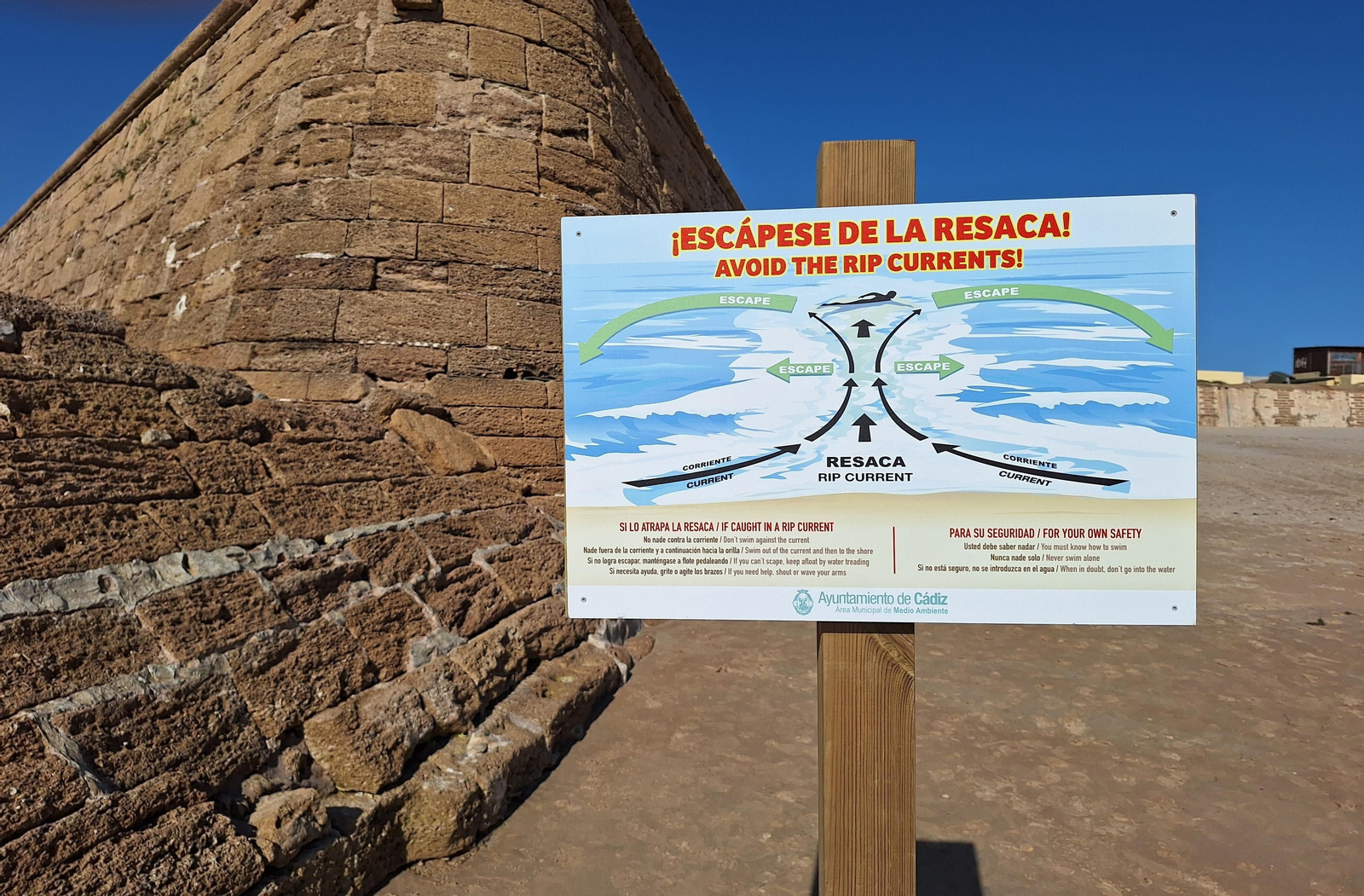 Cartel que advierte sobre la resaca marina ubicado en el muro de la playa La Cortadura