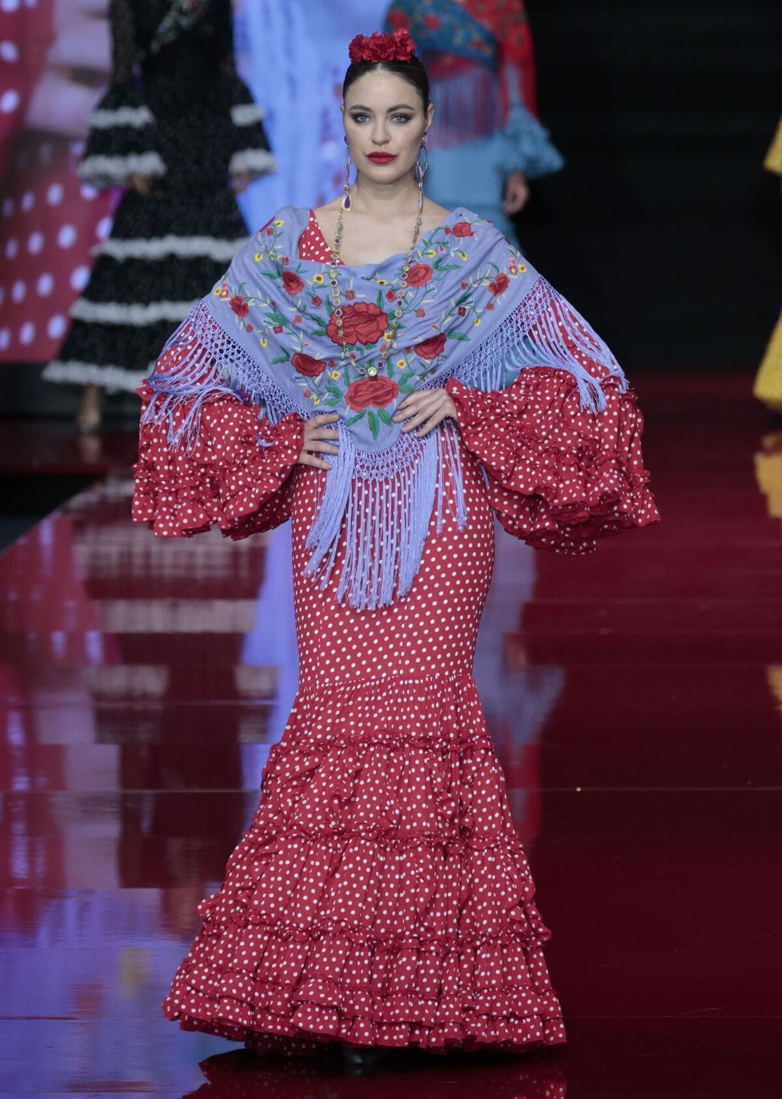 Traje de flamenca rojo combinado con un mantoncillo celeste.