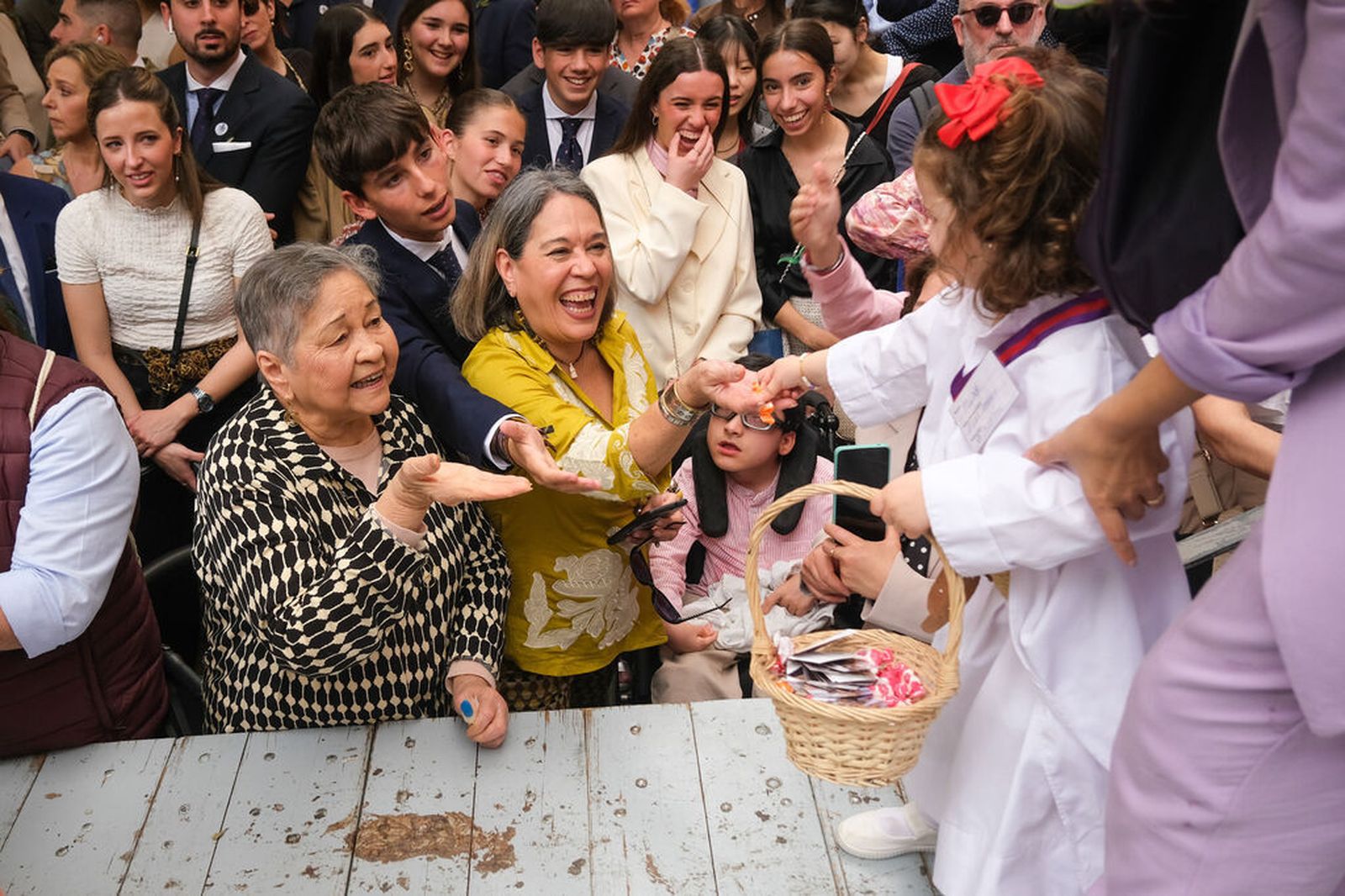 Una monaguilla de la Borriquita reparte caramelos