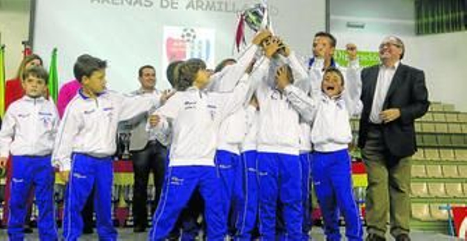 Los componentes del equipo prebenjamín del Arenas de Armilla celebran con jolgorio el trofeo conseguido tras su brillante pasada temporada.
