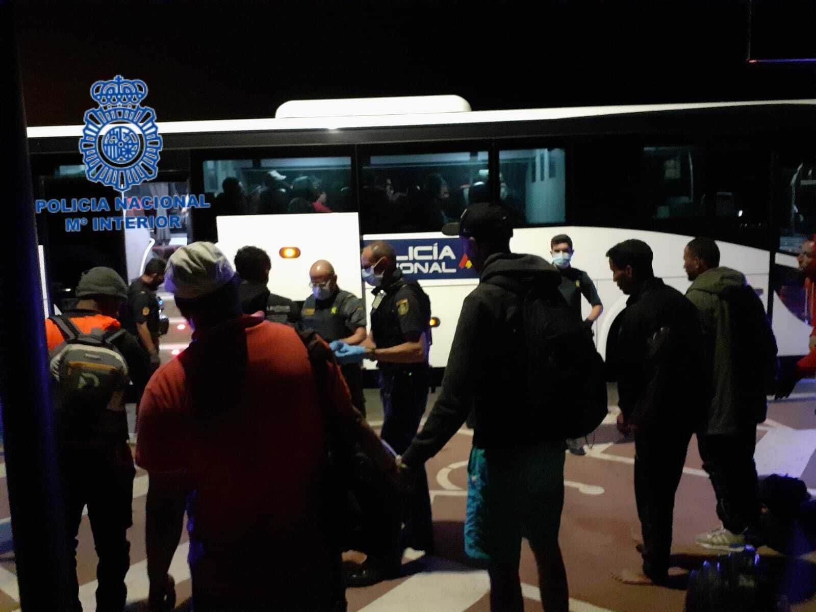 Inmigrantes que desembarcaron en la playa de Camposoto, en el momento de ser trasladados en el autobús de la Policía.