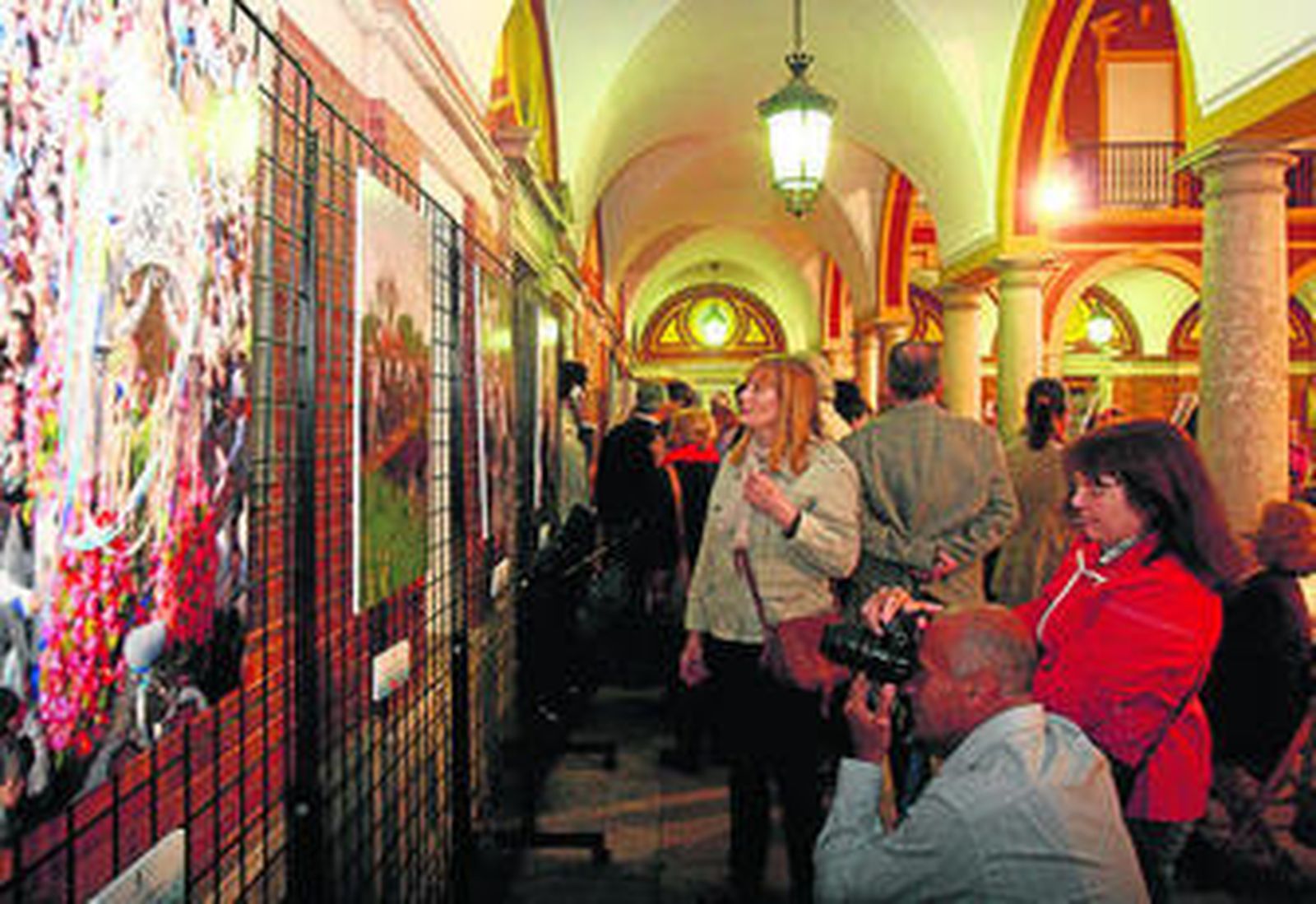 1. Un gran número de personas acudió al acto inaugural de la exposición. 2. El director de Huelva Información, Javier Chaparro, habla con el ganador del concurso, Pedro Ruiz-Constantino, ante la mirada del teniente alcalde de Cultura, Manuel Remesal. 3. David Garzón tocando la flauta y el tamboril. 4. Dos mujeres, ante la obra ganadora. 5. No faltó en el acto una copa de manzanilla.