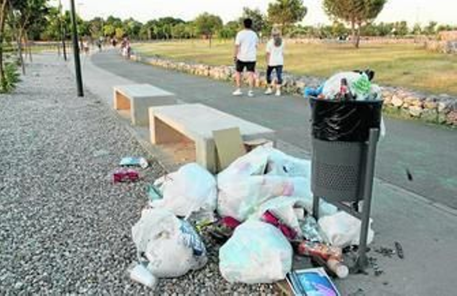 Una papelera rebosante de basura sirve de bienvenida para los paseantes.