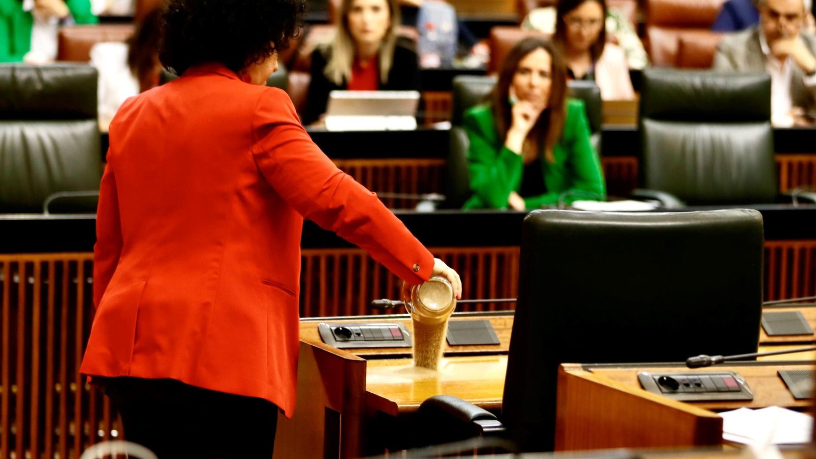 Maribel Mora arroja arena de Doñana en el escaño de Juanma Moreno.