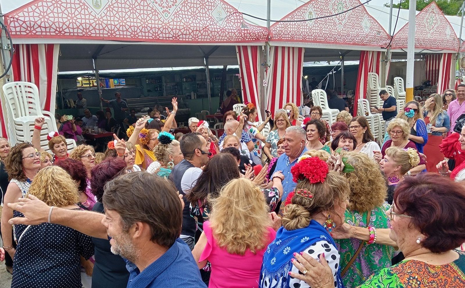Un grupo  muy animado de personas bailando en el Real de la Feria de la Manzanilla de Sanlúcar.