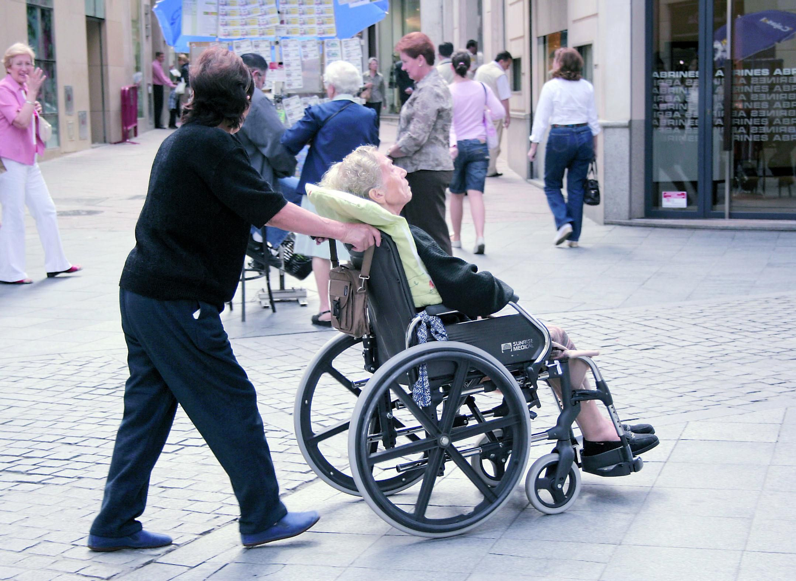 Una cuidadora pasea a una persona dependiente.