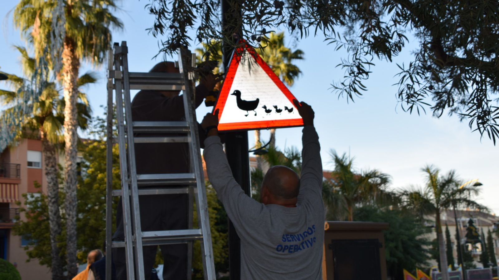 Operarios colocan una de las señales que advierten de la presencia de patos.