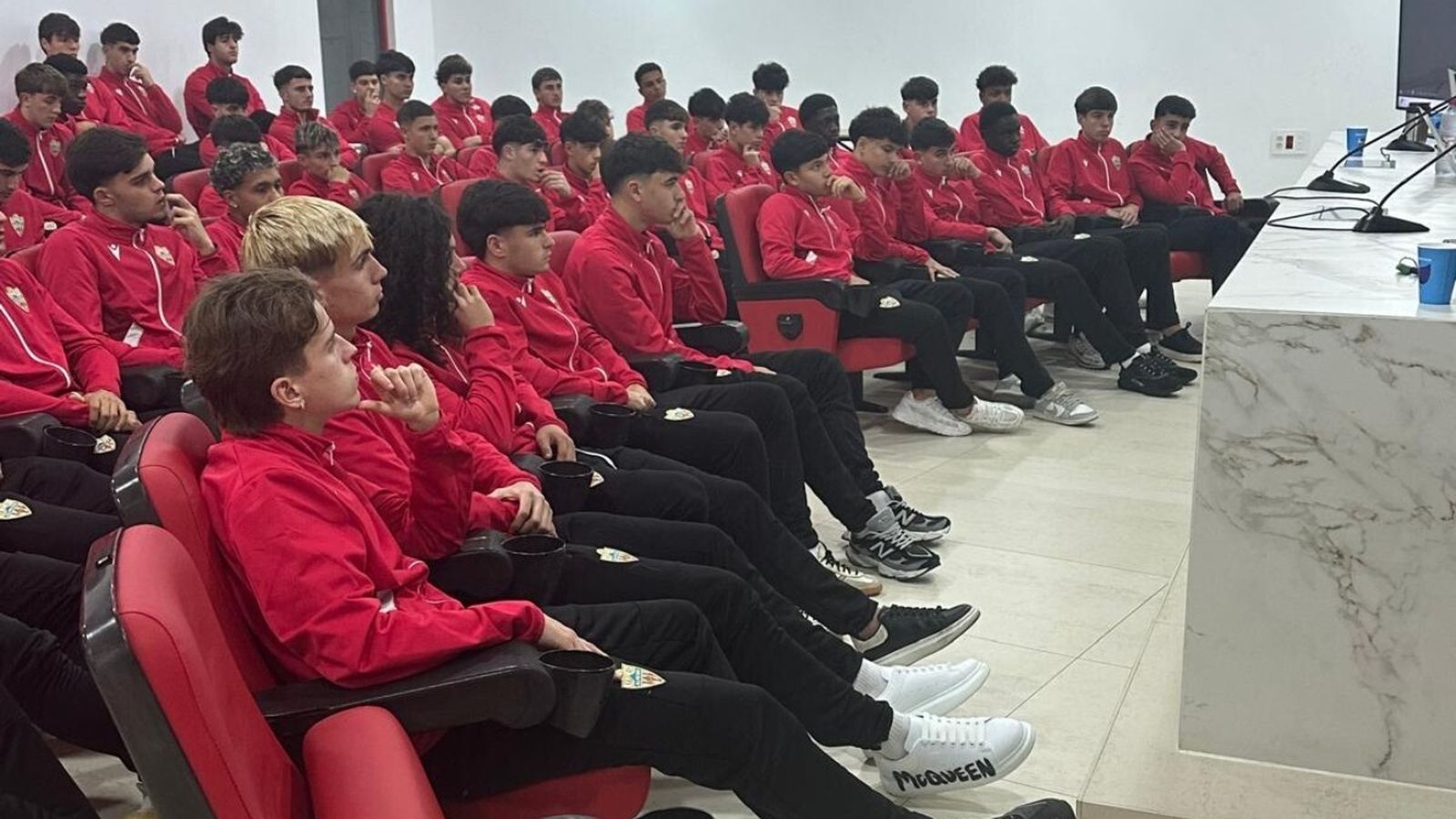 Los futbolistas escuchan la charla impartida en la sala de prensa del estadio rojiblanco.