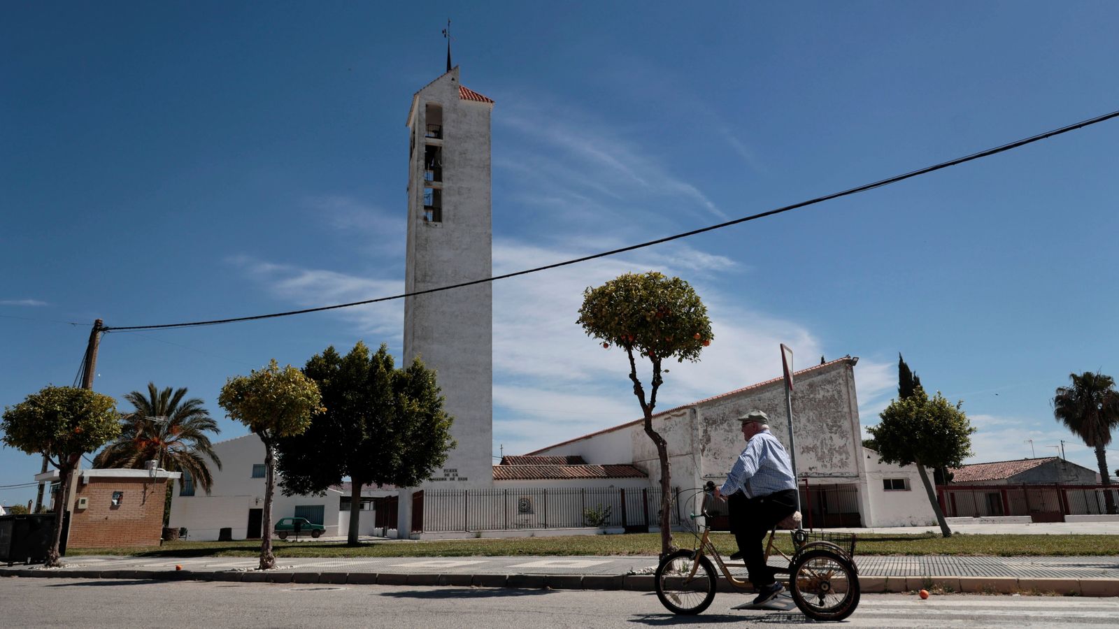 Un hombre pasa en bicicleta ante la iglesia del Trobal.