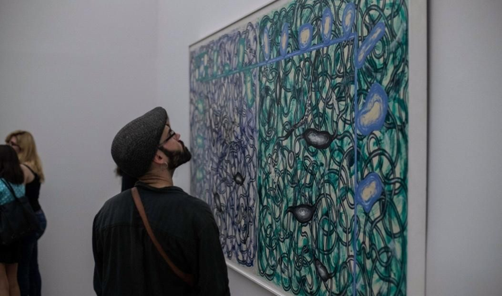 Un visitante contempla una de las obras de Gordillo.