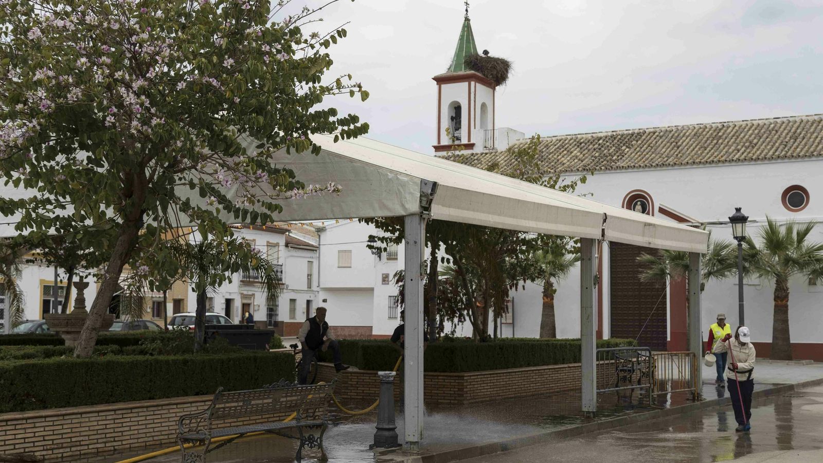 Operarios municipales limpian los restos del Huerto de los Olivos que se monta en la plaza el domingo de Resurrección, al fondo, junto a la Iglesia, se quema el Judas.