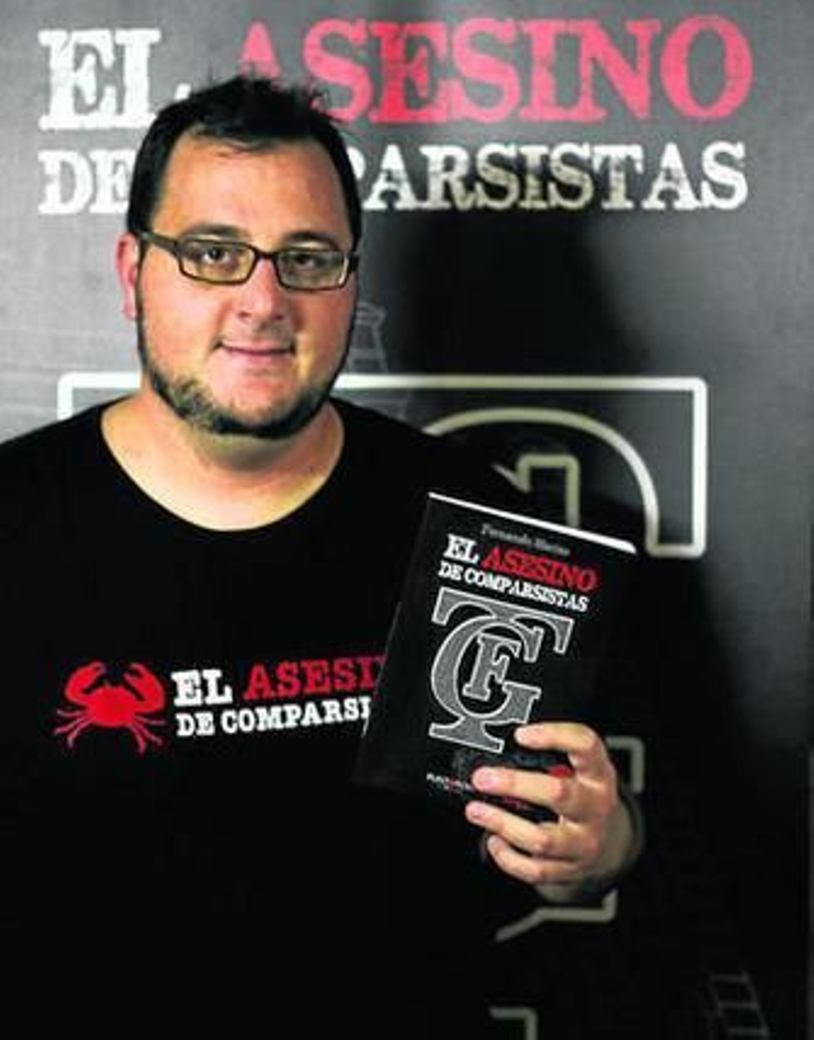 El escritor Fernando Macías, con un ejemplar de su novela.