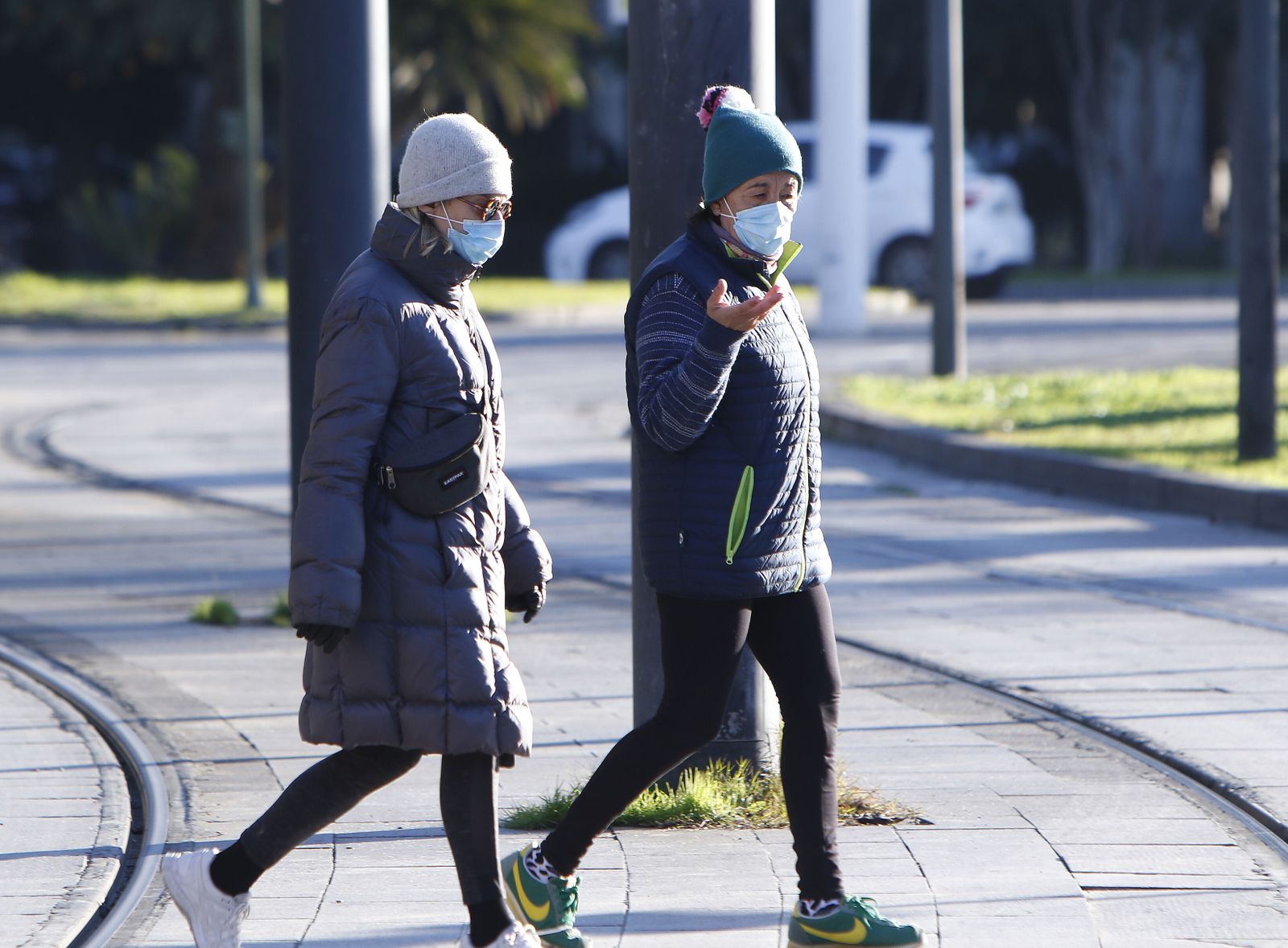Dos personas pasean protegidas del frío.